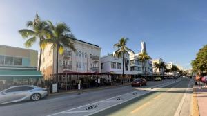 a city street with palm trees and cars on the road at Meet Me On Ocean Dr - Cozy Stay Steps From Beach in Miami Beach