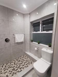 a bathroom with a toilet and a shower at 20 Montego Bay - Caribbean Estates in Port Edward