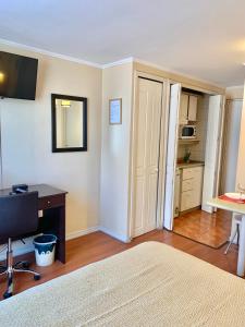 Un dormitorio con una cama, un escritorio y una silla. en CentriK Location Apartments Encomenderos 200, en Santiago
