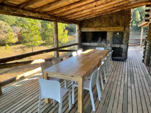 einen Holztisch und Stühle auf einer Terrasse in der Unterkunft CABAÑA SIERRAS de CORDOBA in San Clemente