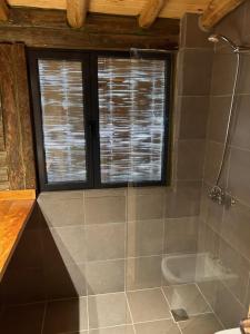 ein Bad mit einer Dusche, einer Badewanne und einem Fenster in der Unterkunft CABAÑA SIERRAS de CORDOBA in San Clemente