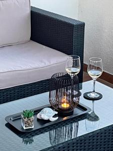 a table with two wine glasses and a candle on it at Apartman Morena in Vlašići