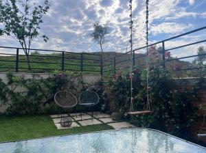 a garden with two chairs and a swimming pool at Stylish two bedroom house with private pool in Tirana