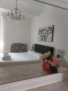 1 dormitorio con 1 cama y un jarrón de flores sobre una mesa en Appartamento La Chicca en Prato