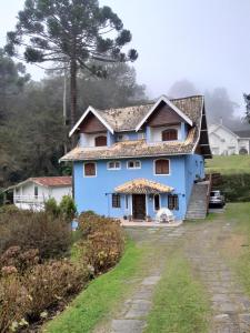 una casa azul con techo de gambrel en Casa Carvalho, en Campos do Jordão
