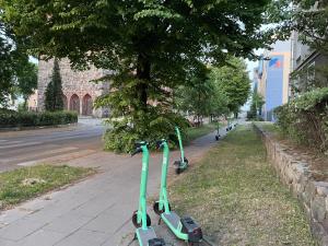 a pair of green scooters parked on a sidewalk at Lux New Port in Gdańsk