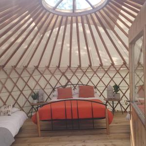 a room with a bed in a yurt with a window at The Lawn Yurt in Tullow