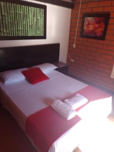 a bedroom with two beds with red and white pillows at FINCA HOTEL SANTO TOMAS REAL in Rionegro