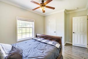 1 dormitorio con 1 cama y ventilador de techo en Jacksonville Home with Deck - 30 Mi to Talladega!, en Jacksonville