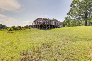 ein Haus auf einem Hügel mit einem Feld in der Unterkunft Jacksonville Home with Deck - 30 Mi to Talladega! in Jacksonville