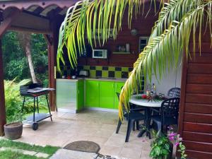 una cocina con armarios verdes y una mesa en un patio en 1 bungalow en bois type chalet, en Sainte-Anne