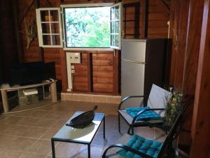 a living room with a bird on a table and a refrigerator at 1 bungalow en bois type chalet in Sainte-Anne