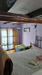 a bedroom with two beds and a room with a window at Casa Rural Obrador. in Montoro de Mezquita