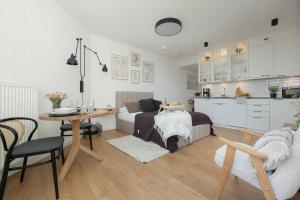 a kitchen and a living room with a bed and a table at Pinea 718 SeaView in Pobierowo