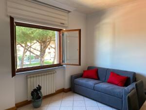 a living room with a blue couch and a window at Domus Iuturnae in Castel Gandolfo