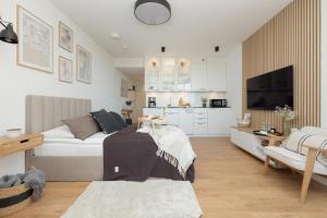 a bedroom with a bed and a living room at Pinea 718 SeaView in Pobierowo