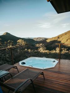bañera de hidromasaje en una terraza con vistas a las montañas en Rustik, en Alto Paraíso de Goiás