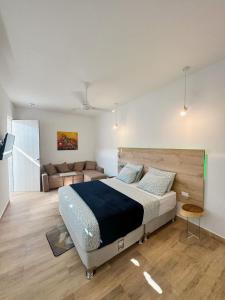 a bedroom with a large bed and a couch at Comunidad Calle 13 Hotel Boutique in Santa Marta