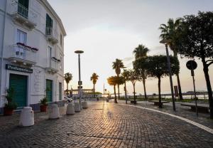 a cobblestone street with palm trees and a building at AquaMar Bed and Breakfast in Crotone