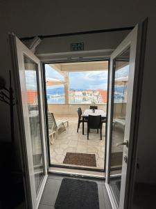una puerta abierta a un patio con mesa y sillas en Amazing View Apartment in the heart of Postira en Postire