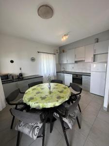 uma cozinha com mesa e cadeiras e uma cozinha com armários brancos em Amazing View Apartment in the heart of Postira em Postira