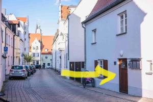 una strada cittadina con edifici bianchi e frecce gialle di Altstadtperle m. schönem Flair, 65 qm, großes Bett a Ingolstadt