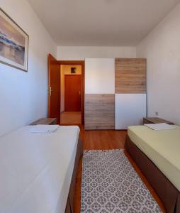 Habitación pequeña con 2 camas y puerta en Apartment DRAZENKA, en Novalja