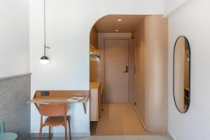 a room with a table and a chair and a mirror at Evripides Hotel in Athens