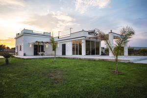 una casa blanca con césped delante en Villa Gallieco, en Noto