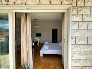 a door to a room with a bed and a desk at Villa Dante in Trogir