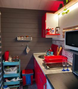 una pequeña cocina con armarios rojos y fregadero en Chalet Puerto Escondido en Telde