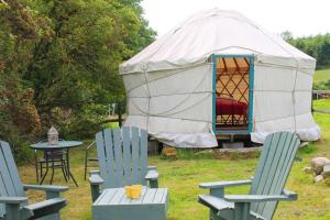 una yurta con sedie, tavolo e tenda di The Wood Yurt a Tullow