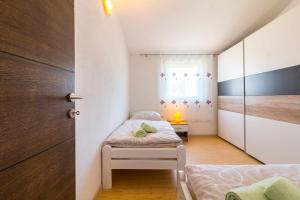 a small bedroom with two beds and a window at Apartment Hilda in Solin