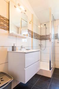 a white bathroom with a shower and a sink at Apartment Hilda in Solin +23 photos