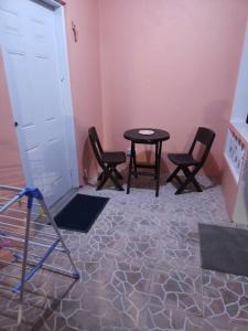 a room with chairs and a table and a door at Sunset Breeze in Pointe Michel