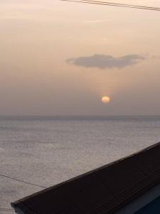 een zonsondergang boven de oceaan met de zon in de lucht bij Sunset Breeze in Pointe Michel