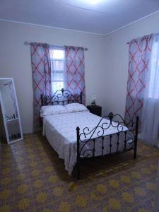 een slaapkamer met een bed en 2 ramen en een spiegel bij Sunset Breeze in Pointe Michel