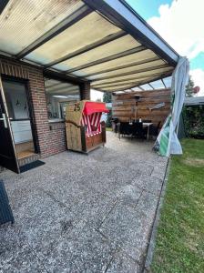 awning over a patio with a table and chairs at Haffkrug Beach Bungalow in Scharbeutz