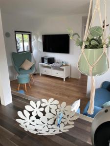 ein Wohnzimmer mit einem TV und einer Blumenschale in der Unterkunft Haffkrug Beach Bungalow in Scharbeutz