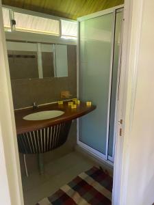 y baño con lavabo y espejo. en Pension Reva Teahupoo, en Toanoano