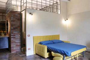 a bedroom with a bed with a blue comforter at Suite I Tre Cardilli in Matera