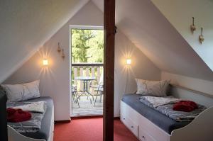 a attic room with two beds and a balcony at Erzgebirgshotel Misnia Bärenfels in Kurort Altenberg