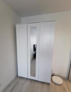 a large white cabinet in a room with a toilet at Home 4 YOU - self check-in in Ventspils