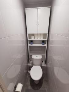 La salle de bains est pourvue de toilettes blanches et d'une armoire. dans l'établissement Home 4 YOU - self check-in, à Ventspils
