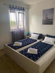 a bedroom with two beds with blue and white sheets at Villa LILI in Rogoznica