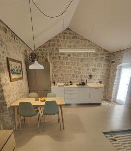 a kitchen with a table and chairs in a room at Skalina House in Tivat