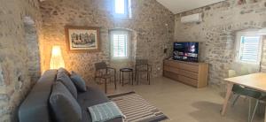 a living room with a couch and a tv at Skalina House in Tivat