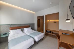 a hotel room with two beds and a desk at Evripides Hotel in Athens