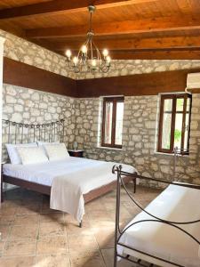 een slaapkamer met een bed en een stenen muur bij Carmel Villas in Drymon +98 foto's