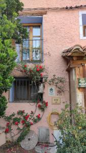 a building with a window with flowers on it at Casa Rural Obrador. in Montoro de Mezquita